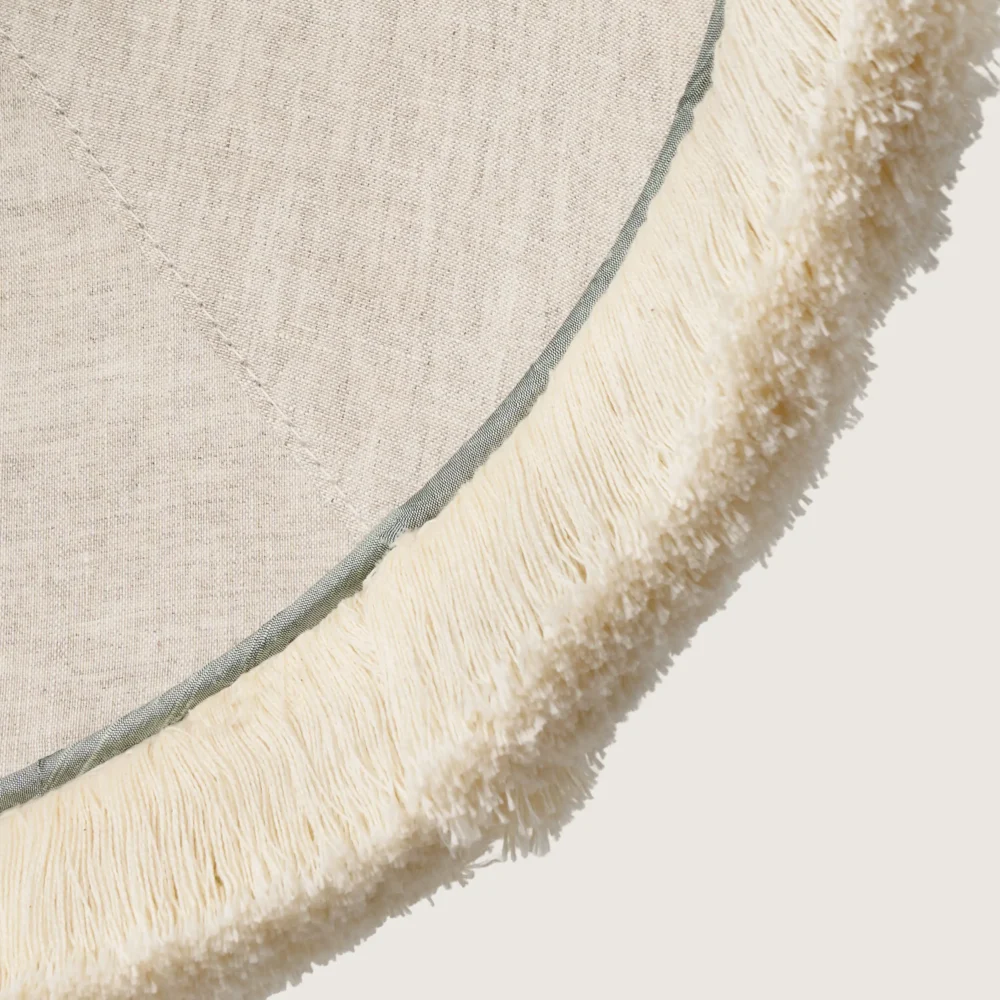 A close-up of the beautifully formed cone-shaped lampshade, finished with a delicate white fringe along the bottom edge.