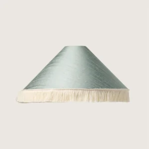 A beautifully formed conical lampshade, finished with a delicate white fringe along the bottom edge.