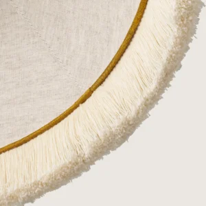 Fredzle.kolor5-detal A close-up of the beautifully formed yellow cone-shaped lampshade, finished with a delicate white fringe along the bottom edge.