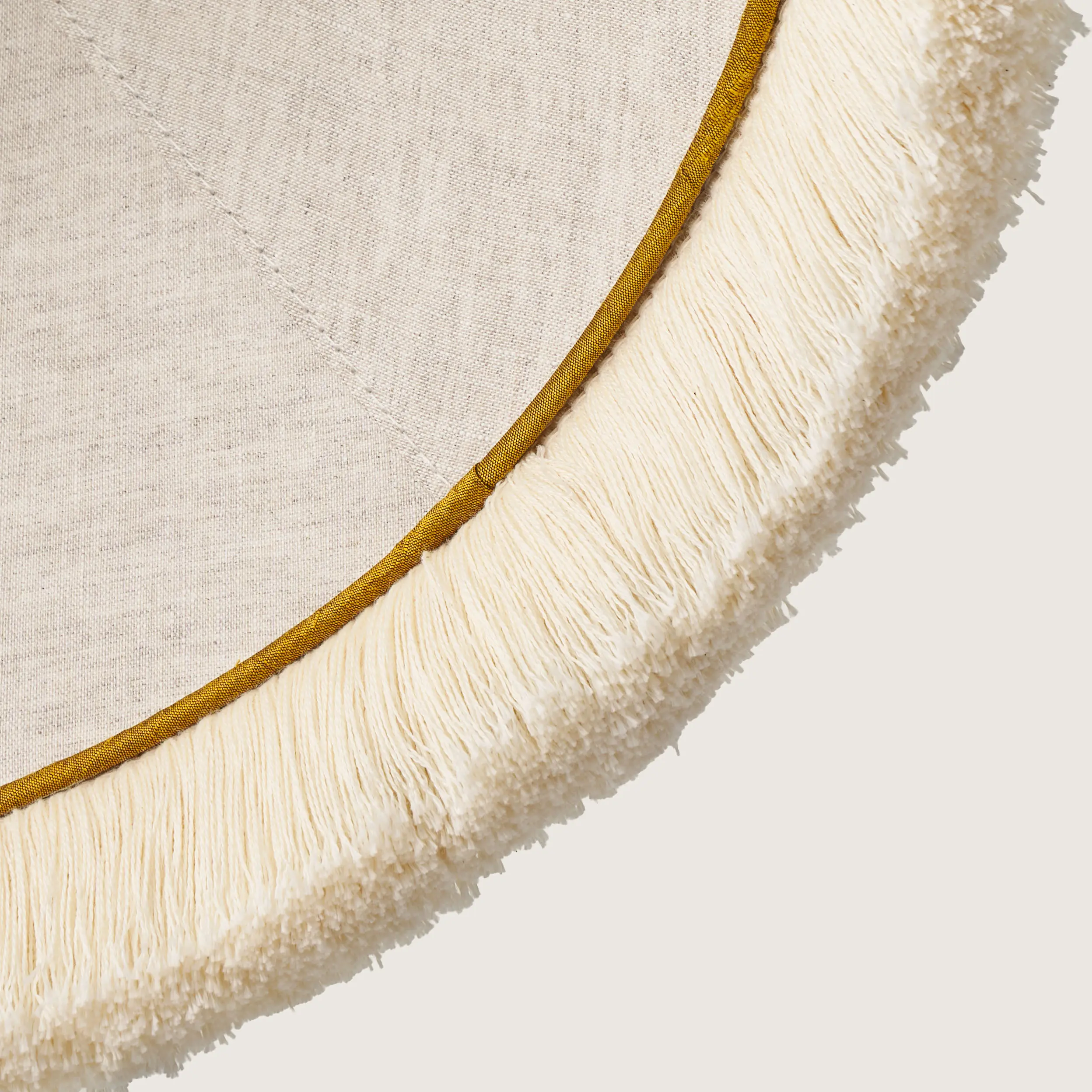 Fredzle.kolor5-detal A close-up of the beautifully formed yellow cone-shaped lampshade, finished with a delicate white fringe along the bottom edge.