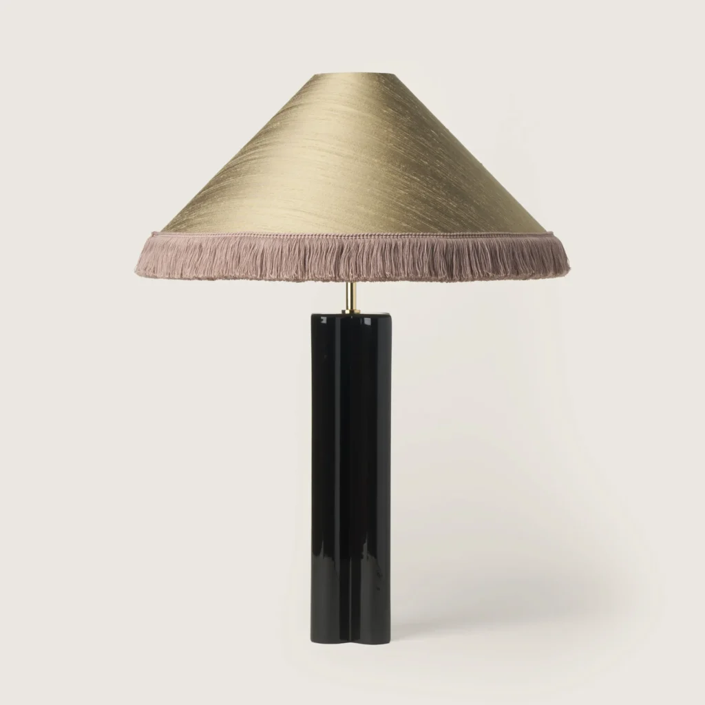 Elegant table lamp with a gray shade, gray fringe, and a black base.
