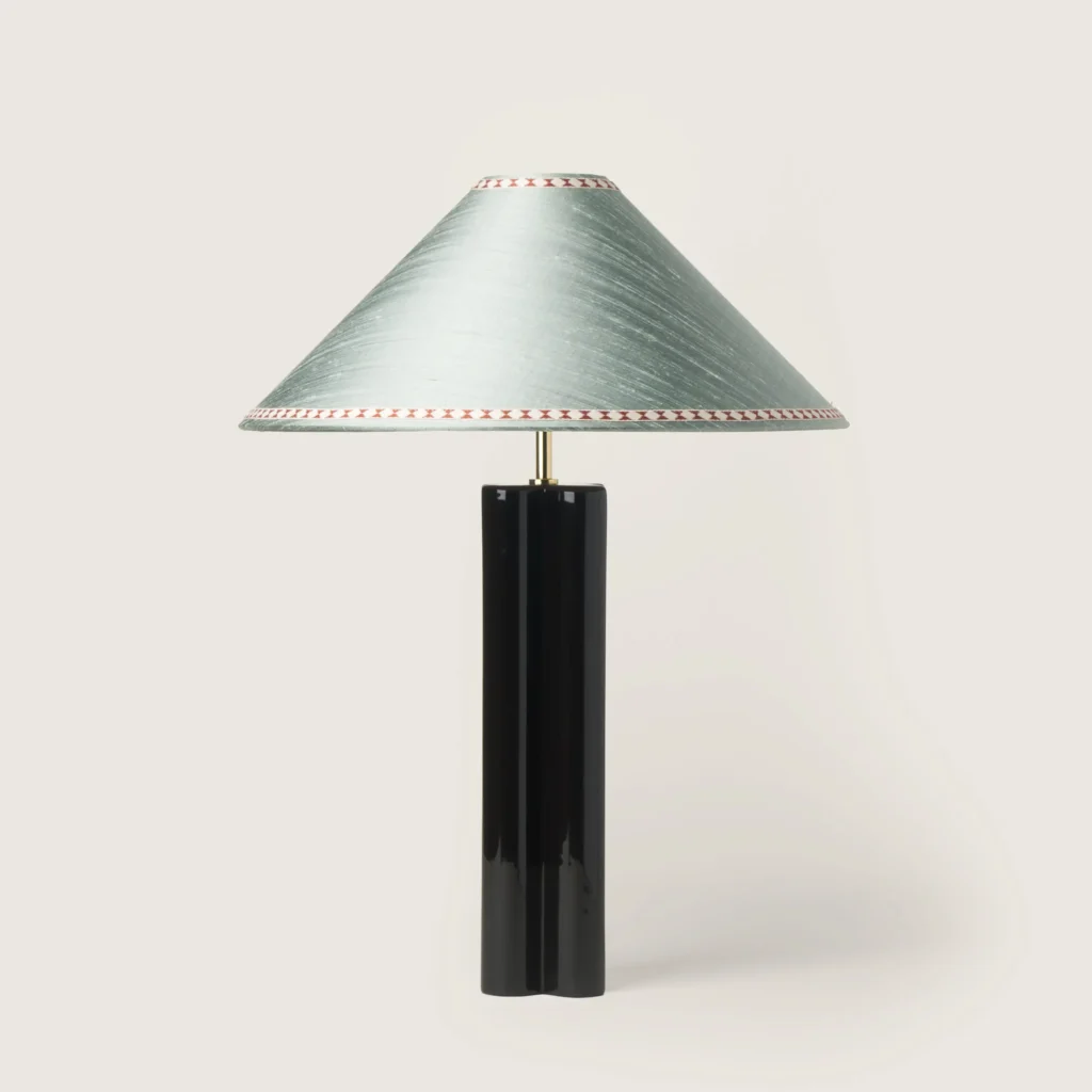 Elegant table lamp with a gray shade, ribbon, and a black base.