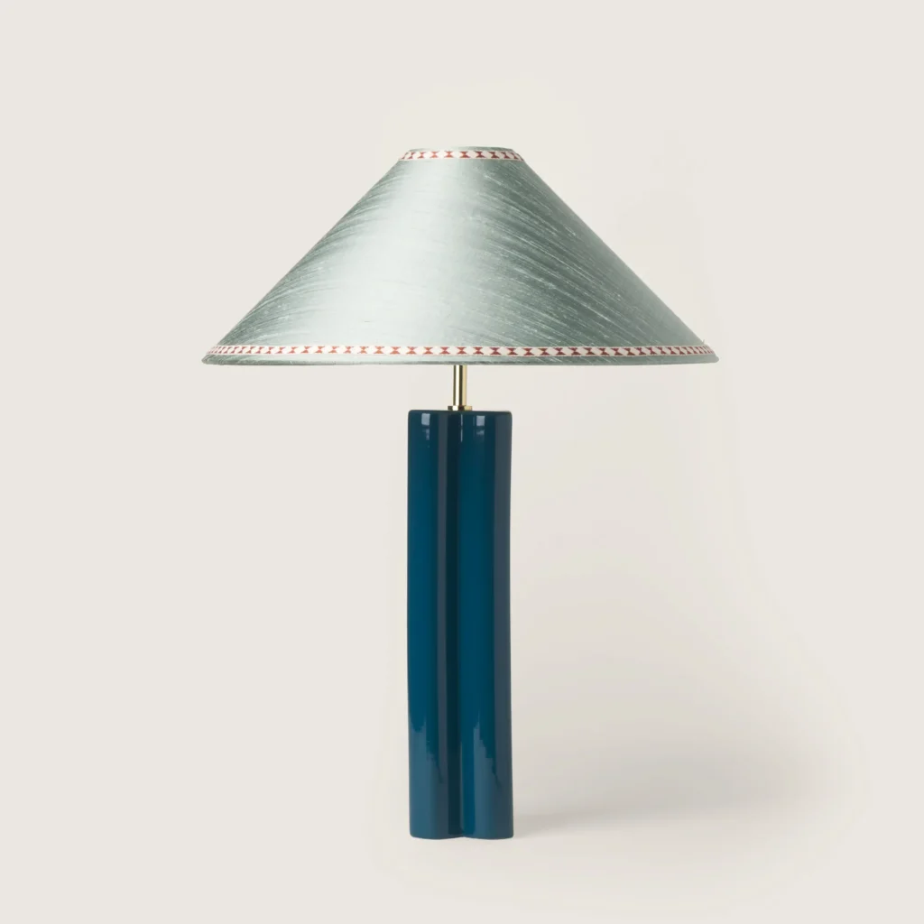 Elegant table lamp with a gray shade, ribbon, and a blue base.