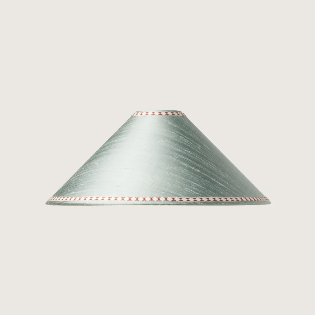 A beautifully formed grey conical lampshade, decorated with a delicate geometric pattern along the top and bottom edges.