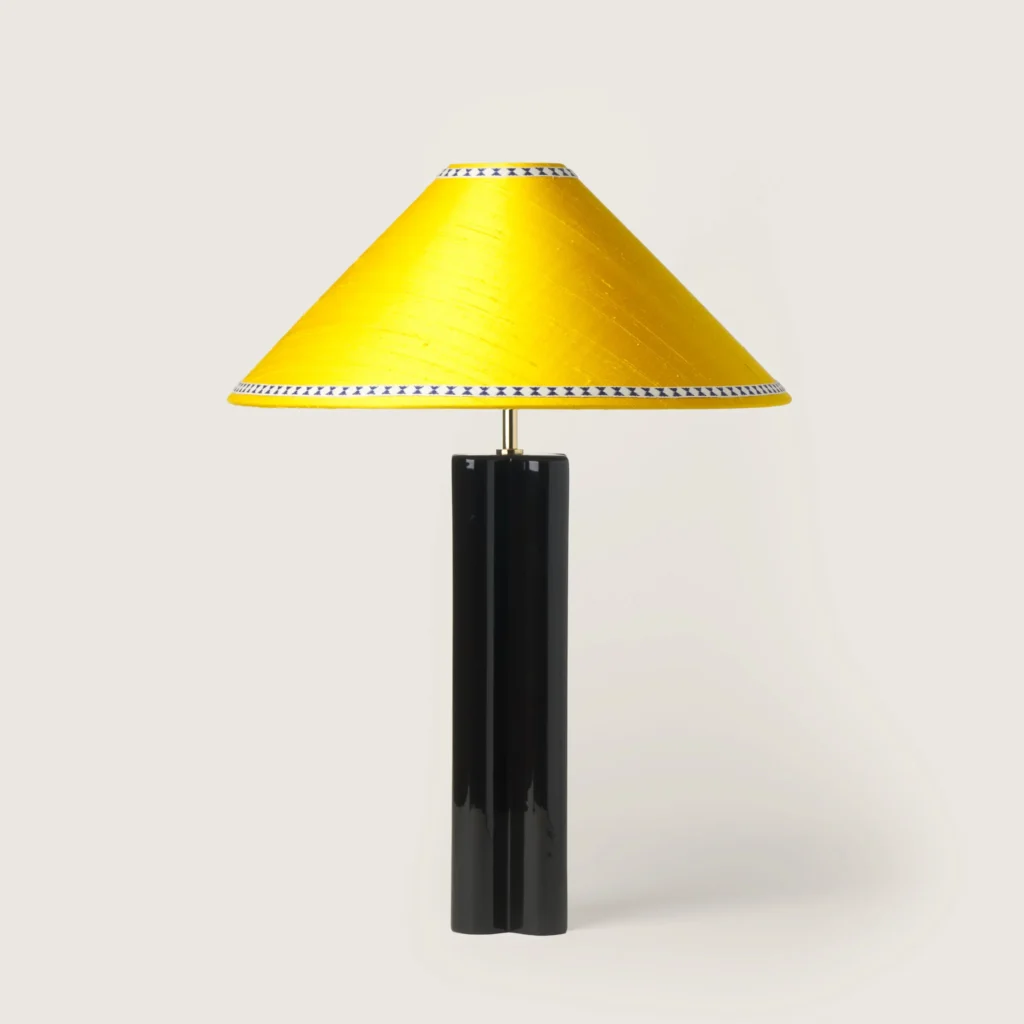 Elegant table lamp with a yellow shade, ribbon, and a black base.