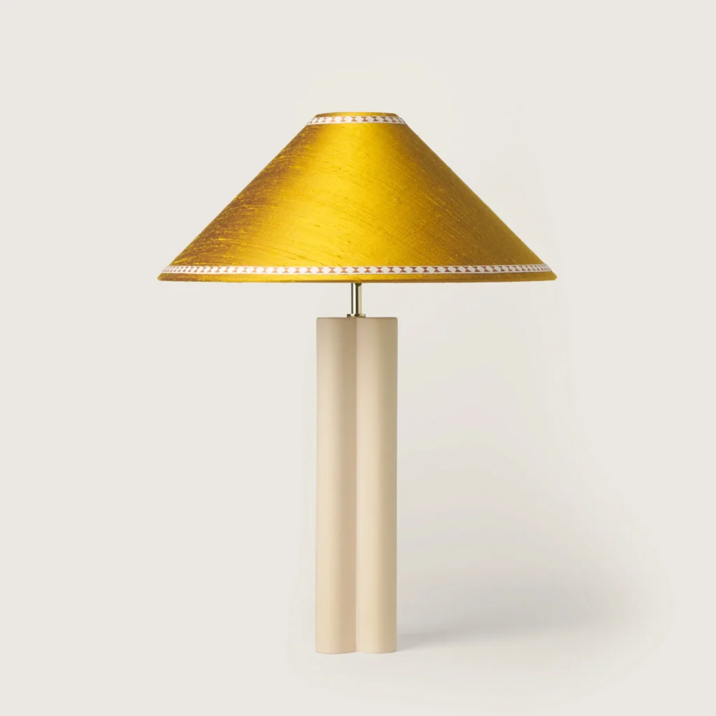 Elegant table lamp with a yellow shade, ribbon, and a cream base.