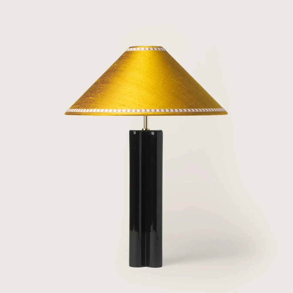 Elegant table lamp with a yellow shade, ribbon, and a black base.