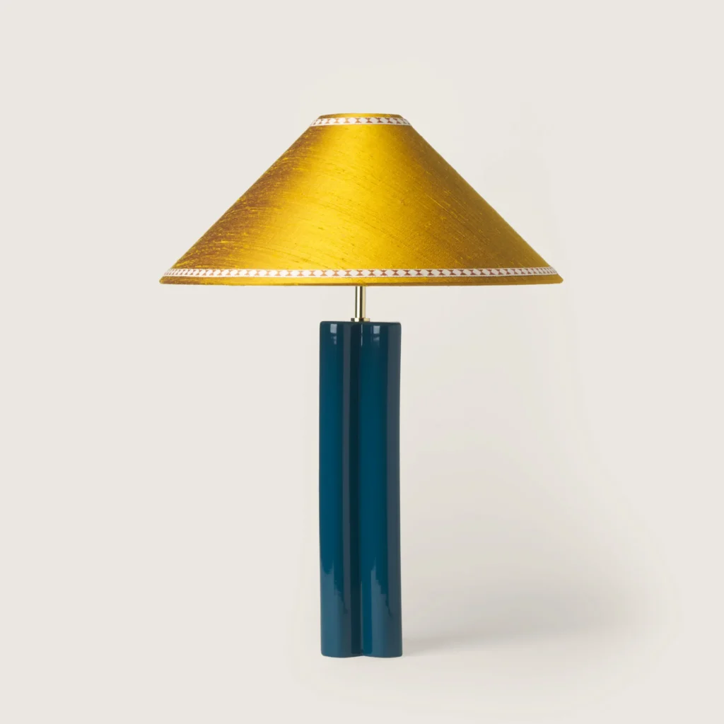 Elegant table lamp with a yellow shade, ribbon, and a blue base.