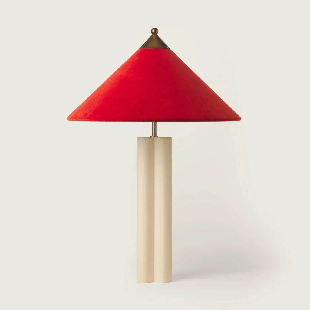 Elegant patinated table lamp with a red velvet shade and cream base.