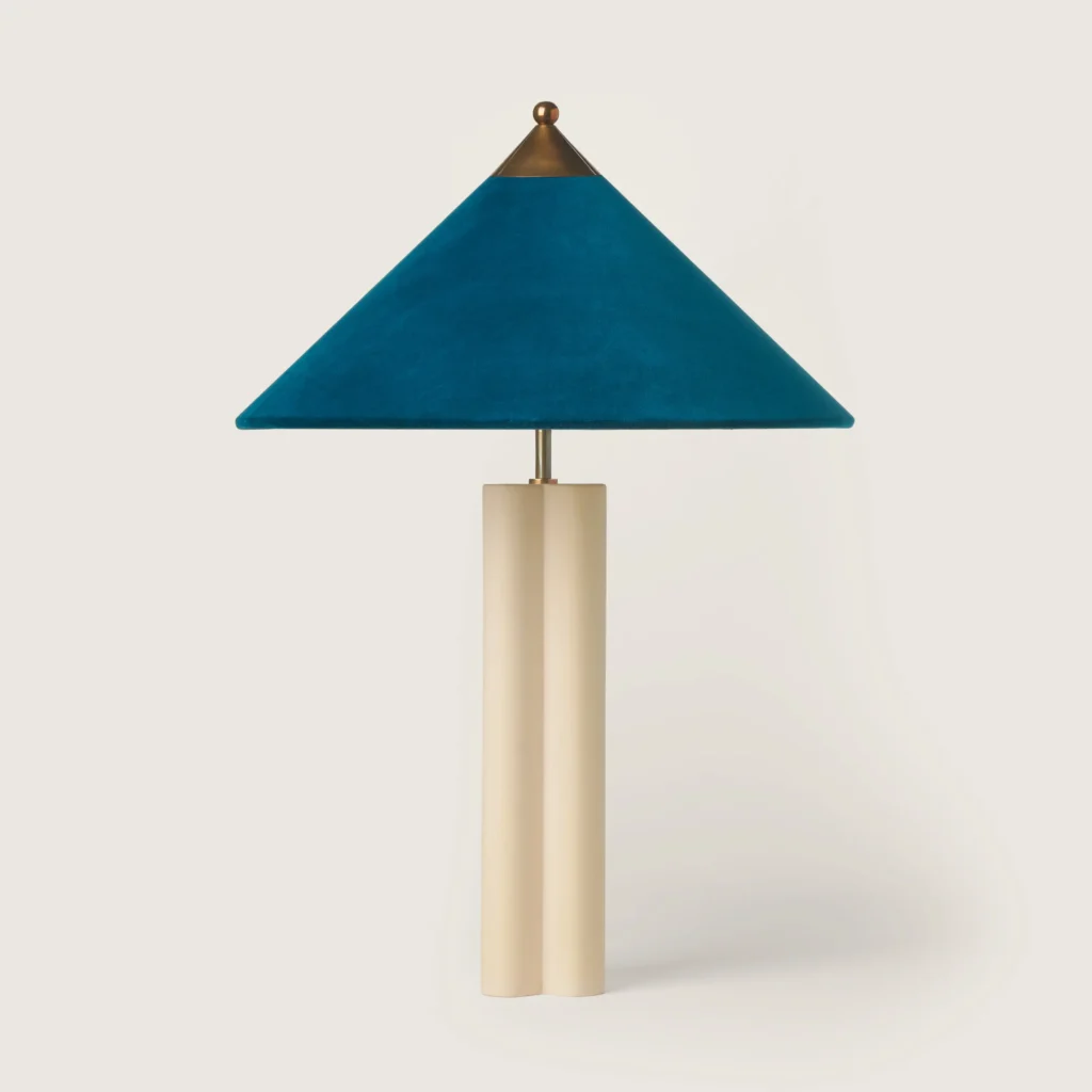 Elegant patinated table lamp with a turquoise velvet shade and cream base.