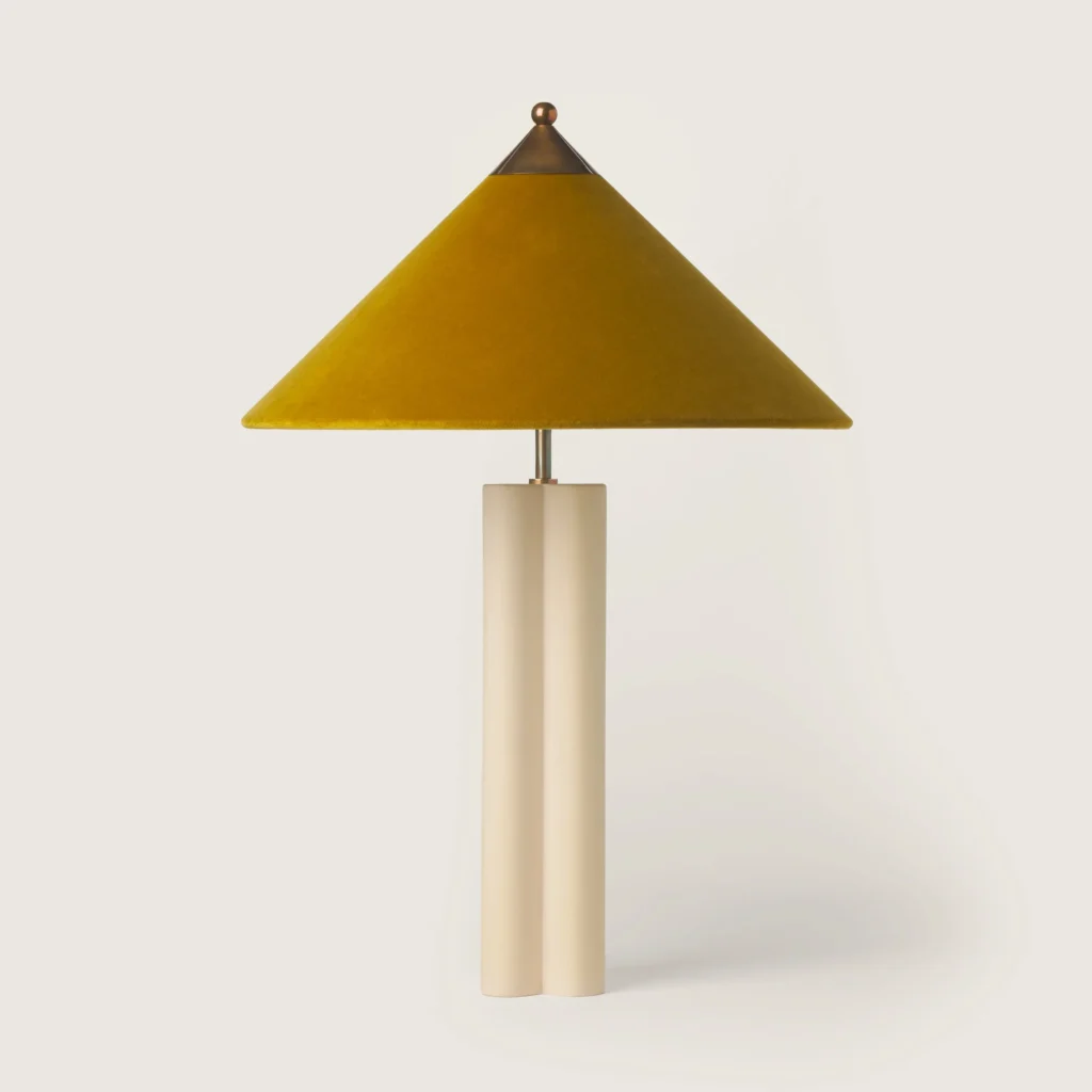 Elegant patinated table lamp with a yellow velvet shade and cream base.